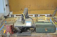 Wide desk view showing red bench vise, Craftsman scroll saw, metal toolbox, and yellow 48-inch level in background