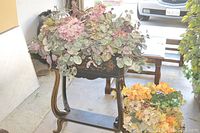 Wooden plant box stand with faux flowers placed on it.