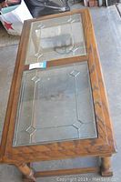 Overall view of the rectangular wooden coffee table with two leaded glass panels on top visible, showing the size and condition including wear and damage.