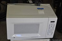 Front view of white G.E. microwave oven with control panel and closed door