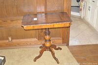 Wooden pedestal base and legs of the antique table showing detail in craftsmanship and structure.
