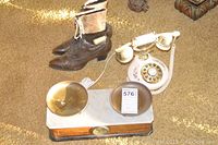 Overview of the lot showing vintage boots, antique scale, and rotary phone