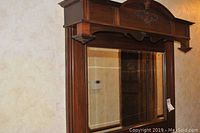 Front view showing the full mirror with decorative wood frame and top arch detail.