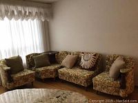 Vintage 4-piece sectional couch arranged in a corner with cushions and a small wooden top on the corner section.