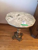 Top-down view showing the scalloped white and grey marble top with swirling pattern.