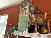 Photo showing several orange glass candle holders in vintage style and other decorative items on shelf