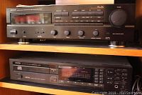 Receiver and CD player stacked on shelf, both fronts visible.