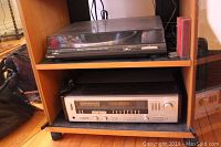 Turntable on top shelf and receiver below inside cabinet