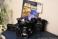 Group shot of Nikon FE2, FE, EM SLR bodies, Nikon Zoom 300 AF point & shoot and Nikon System Handbook