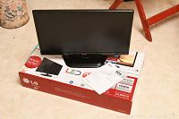 Front view of LG 22 inch LED TV model 22LB4510 sitting on original box with manual on top.