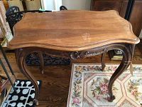 Full view of wood hall table showing rectangular curved top, carved legs, and wear on finish.