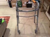 Full front view of gray Guardian walker with visible wear and two front wheels