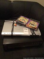 JVC XL-FZ158 CD changer and Zenith DVB410 DVD player stacked, with 'Rock & Roll 50s' CD set on top, showing front panels and remote absence