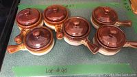 Set of six ceramic French onion soup bowls with a brown lid and handle each.