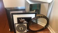 Five pieces leaning together: two mirrors and three framed artwork pieces showing their design and size.