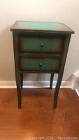 Front view of small antique style two-drawer foyer table with curved legs and distressed turquoise finish.