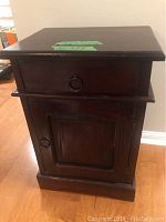 Front view of wooden side table showing drawer with ring pull and cabinet door below with ring pull.
