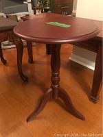 Round wooden side table with scalloped edge top and tripod pedestal base