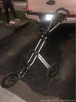 Side view of the 3 wheel golf push cart showing metal frame, large rear wheels and the front single wheel