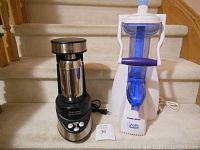 Photo showing two small kitchen appliances side by side on stairs: Waring Professional Martini Maker and Black & Decker Arctic Twist soft serve maker.