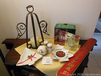 Photo showing Christmas serving dishes, salt and pepper shakers, potpourri holder, wrought iron candle holder, glass votive candle holder, and wooden sign.
