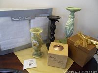 Photo showing boxed Caldwell towel set, green marble vase, black and green candle holders, boxed item with ribbon