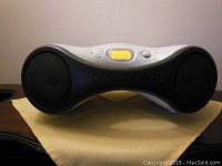 Front view of Sony portable audio system showing dual speakers, SONY branding, and control buttons with orange backlit LCD display.