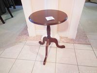 Full view of the Bombay Company round side table showing the pedestal base with three curved legs and 14-inch round top.