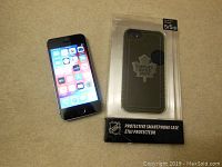 Apple iPhone 5S front screen display and packaged Toronto Maple Leafs phone case side by side.