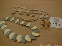 Lot including 3 necklaces and 2 pairs of earrings, showing all items laid out on a surface.