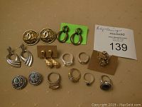 Full lot view showing all rings and earrings laid out on fabric surface