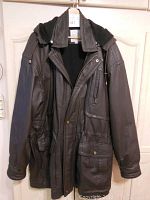 Full front view of the men's dark brown leather coat with detachable hood hanging on a wooden door.