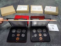 Four uncirculated Canadian coin sets displayed with open presentation cases showing coins and outer protective boxes with informational inserts.