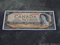 Front side of the 1954 Canadian $50 banknote in protective sleeve, showing Queen Elizabeth II portrait, serial number, and signatures.