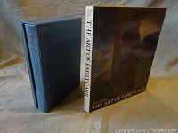 Cloth-bound journal in slipcase standing next to art book cover