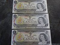 Front side of three uncirculated Canadian one dollar bills with Queen Elizabeth II portrait and coat of arms, arranged in sequence.