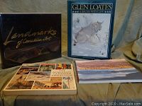 Four books arranged on fabric backdrop showing front covers.
