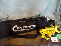 Black carry bag with white 'Centipede Sawhorse' text and yellow clamps displayed on fabric background.
