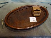 Oval walnut burl serving tray with brass handles and wooden box with Scotty dogs placed on top