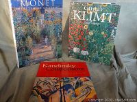 Three coffee table books arranged together with Monet and Klimt standing vertically and Kandinsky book laying flat in front.
