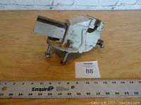 Front view of white metal bench vise marked 'No. 1 Made in England' showing jaws and mounting base with ruler.