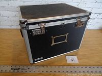 Closed black Vaultz file box showing combination locks and metal corners.