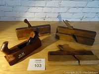 Four wooden hand planes arranged on a wooden surface showing different types: shoulder, beading, roundover, and Lu Ban plane.