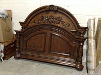 Front view of wooden headboard and footboard showing ornate carved details and paneled center sections with fluted corner posts.