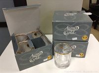 Three boxes containing 12 clear glass tumblers with gold rims.