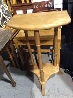Front and angle view of the small wooden side table showing its shape, legs, and bottom shelf.