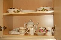 Antique Bridgewood and Son porcelain teapot, jug, creamer jugs, mugs and trinket dish inside cabinet