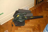 Yardworks electric blower vac and attached collection bag on wooden floor.