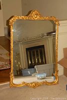 Full front view showing entire gilded wood frame and reflected interior