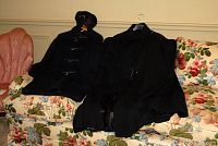 Both the duffle coat and the black wool cape displayed on a floral couch, showing overall lot items